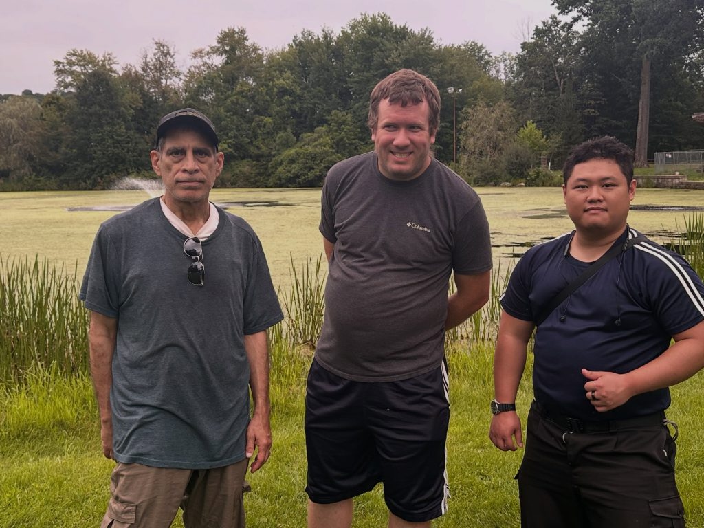 Three members standing together by the pond at Leonard Park in Mount Kisco