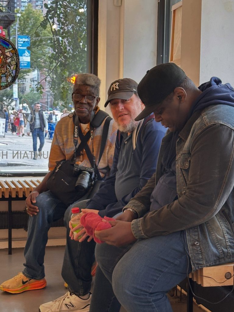 Three members sitting together on a bench at Fountain House Gallery